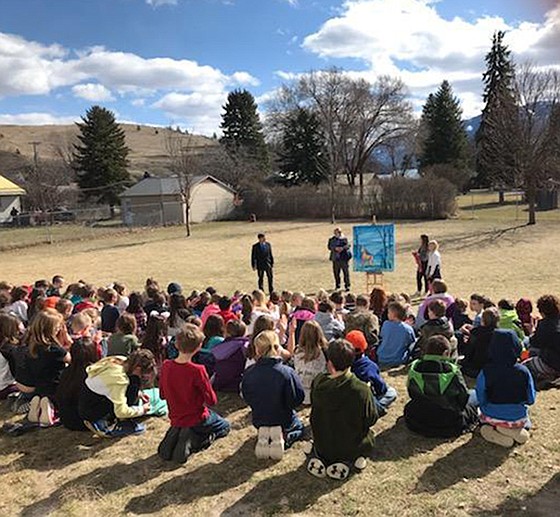 Plains Elementary School students enjoy a sunny day last Thursday as local artist Dave Williams, second from left, presents a painting of the school mascot to Superintendent Thom Chisholm and students Izzy Hardy and Dani Castonguay. (Courtesy photo Plains Schools)