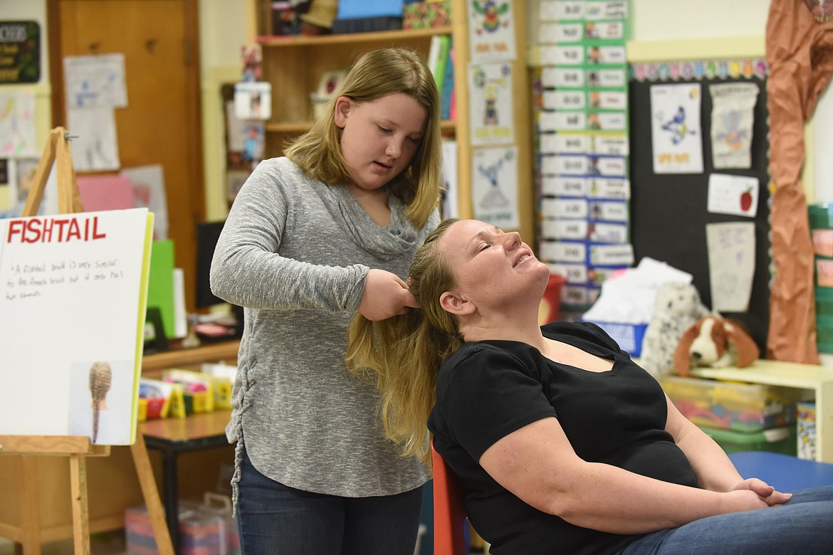 Madison Chojnacky, of Thompson Falls, braids her mother Shannon&#146;s hair during her presentation last Saturday at the Sanders County 4-H Communication Day at Thompson Falls Elementary School. It was the beginning of the event that will end this weekend. (Scott Shindledecker/Valley Press)