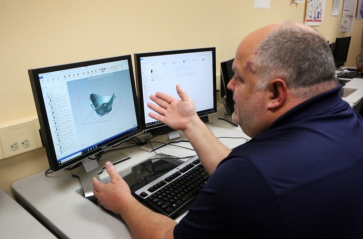 Dan Leatzow, an advanced manufacturing instructor at FVCC, looks at a model of an N95 mask on computer software that shows how machines will create the mask from a solid block of material. (Mackenzie Reiss/Daily Inter Lake)