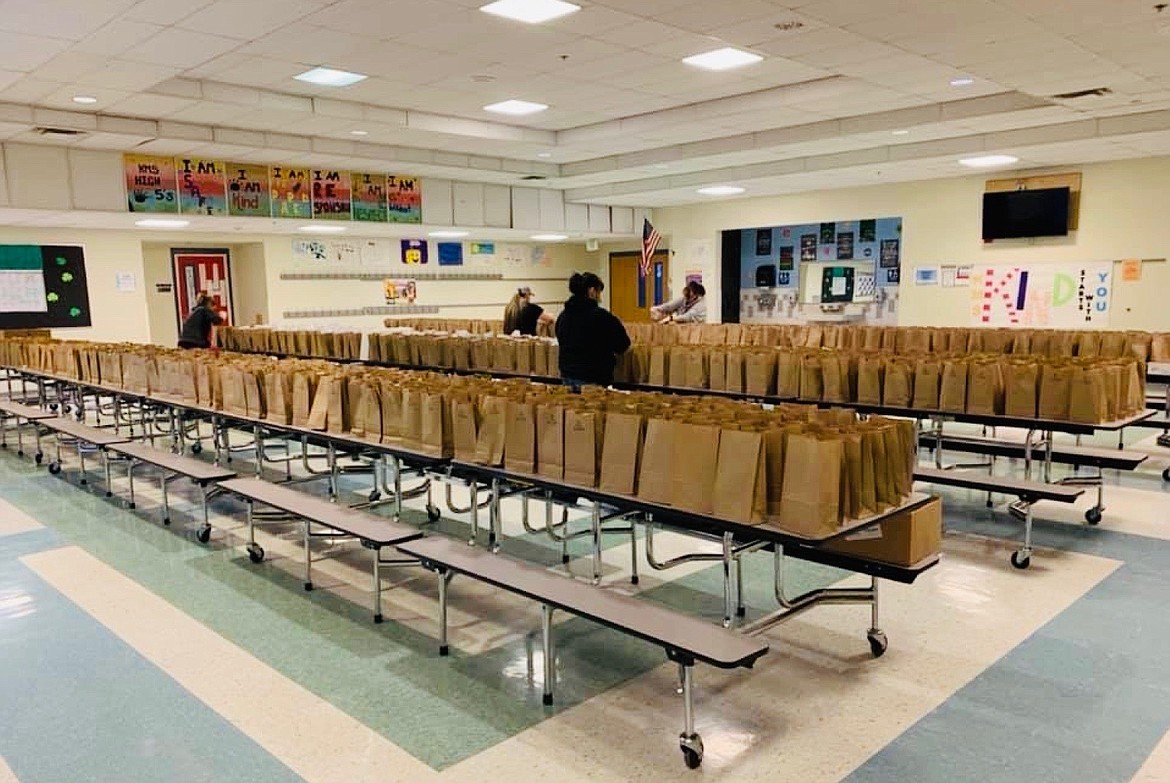 Staff in the Kellogg School District work to fill paper sacks with meals for students in the Kellogg Middle School cafeteria.