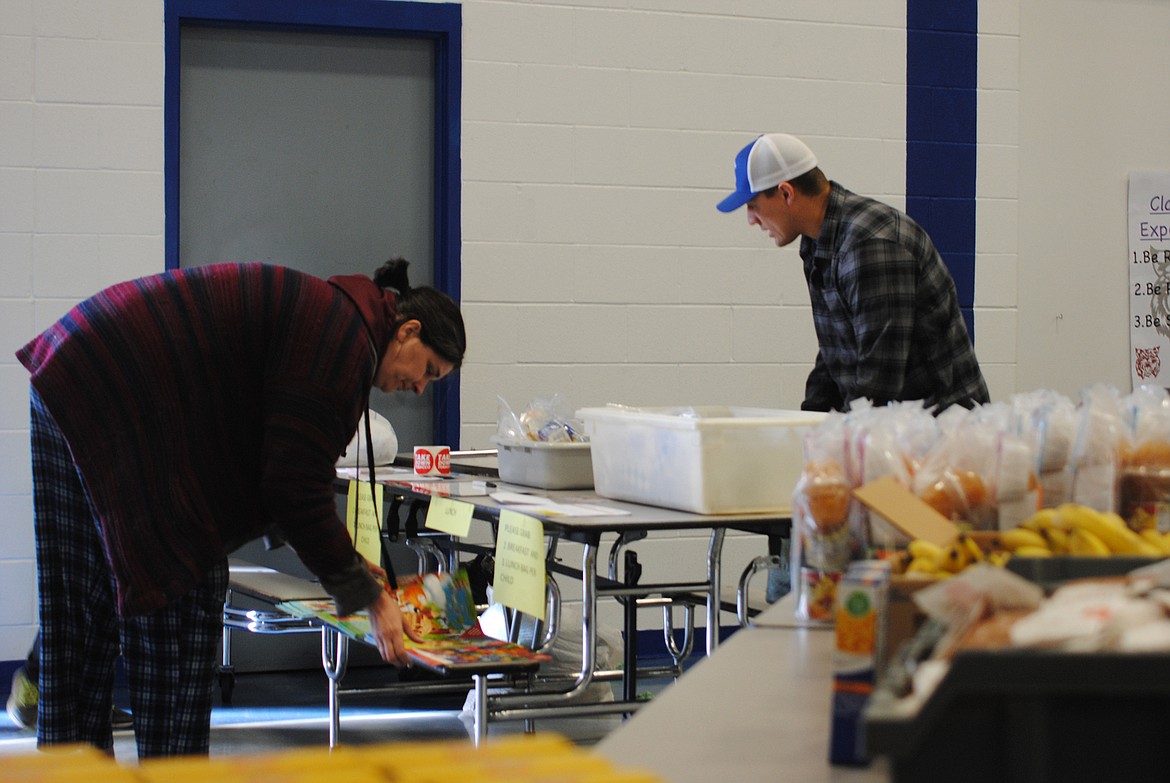 Superior elementary principal Logan Labbe distributes take home instruction packets on March 18 to families. (Amy Quinlivan/Mineral Independent)