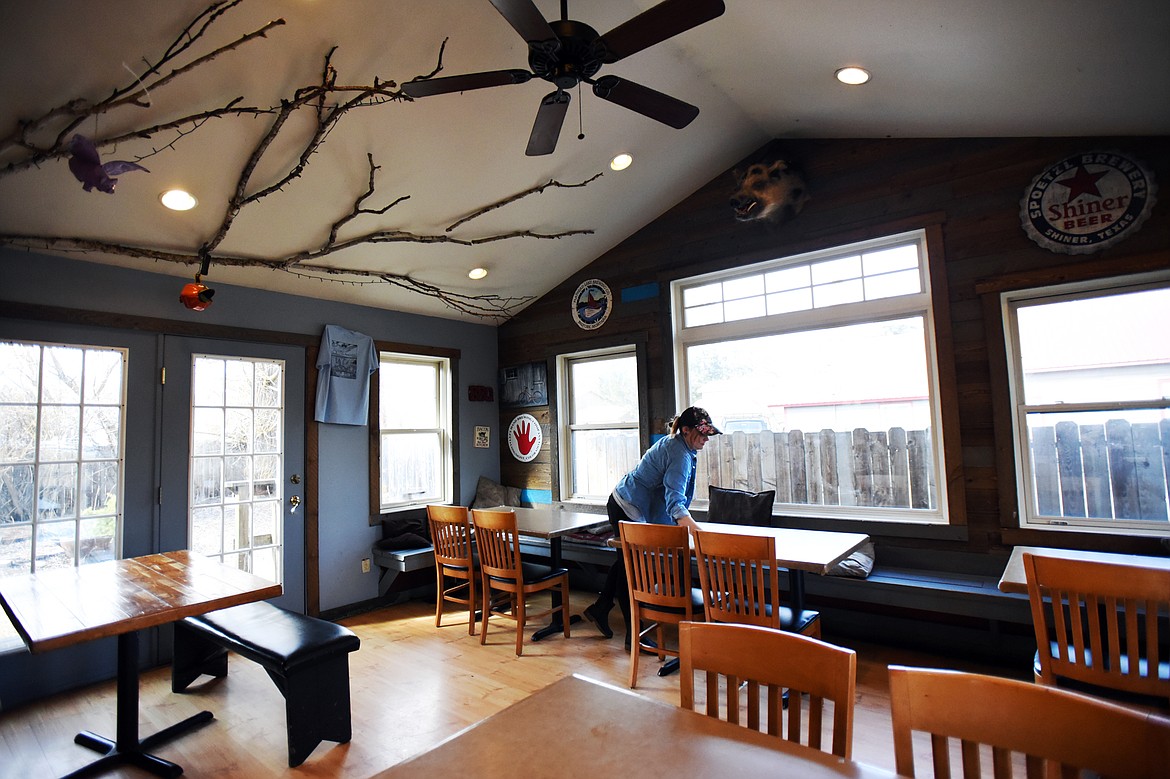 Candace Lost-Bear wipes down tables in the empty dining room at Piggyback BBQ in Whitefish on Thursday, March 19. The abrupt closure of restaurants, bars and related businesses has affected the employment of scores of Flathead Valley workers. (Casey Kreider/Daily Inter Lake)