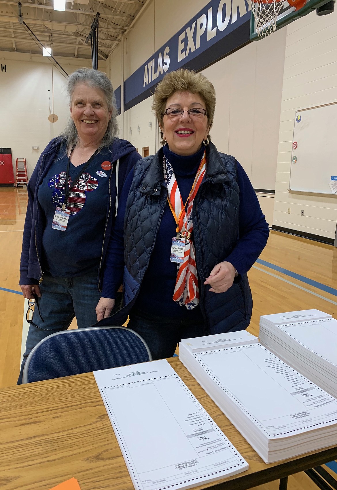 Beverly Guenette, chief judge, deputy of elections, right, and Mary Beth Bowen, poll worker, handing out ballots at precinct 18 during the election Tuesday, March 10. (ELENA JOHNSON)