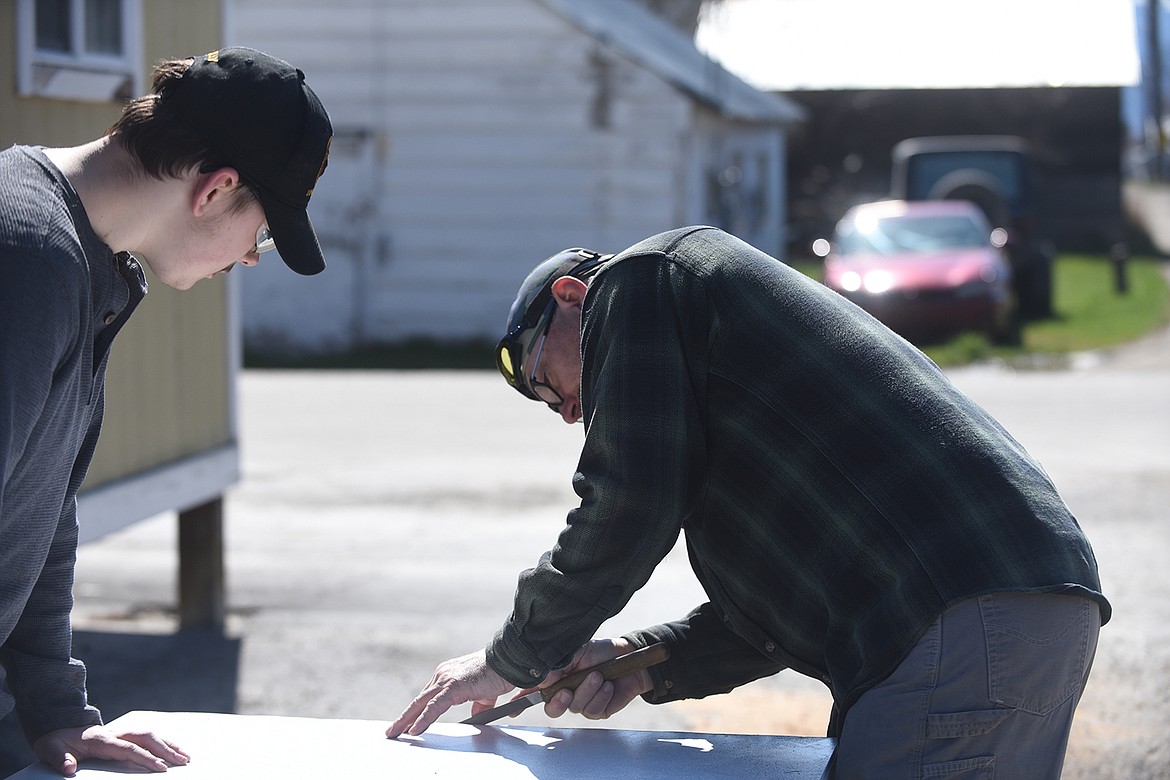 Robyn Largent, right, and his son, William Largent, work on an exterior door before installing it at the Plains Veterans of Foreign Wars Post 3596. The father-son team own Sanders County Locksmith after buying it from local man Earl Edrington last December. (Scott Shindledecker/Valley Press)