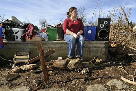 &lt;p&gt;Paige Sizemore, 18, of Lincoln, Ark., sits on the foundation of a home behind a makeshift cross made from debris after a tornado tore through the small town of Cincinnati, Ark., on Friday.&lt;/p&gt;
