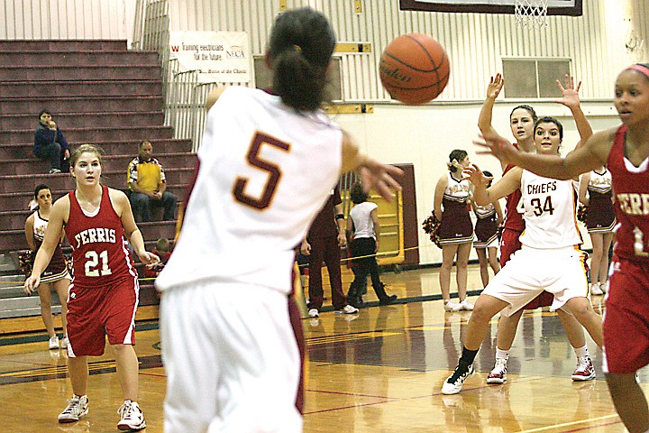 Moses Lake Chief Jordan Loera (5) threads the needle with a pass to teammate Kayla Bernsen (34) during their team's 53-51 win over Ferris last night,