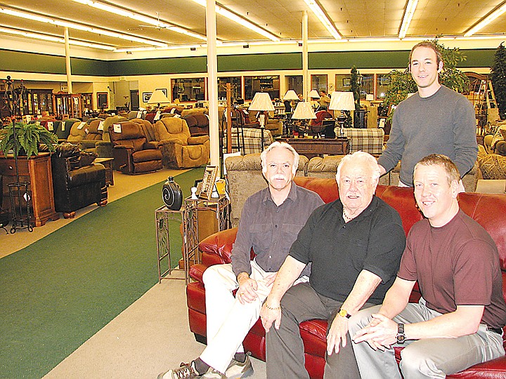 The four generations of Moore Furniture include Lowell Moore, center seated, his sons, Michael Moore, left, and Kelly Moore, and grandson, Matt Moore, standing. The business marks 100 years of operations in 2011.