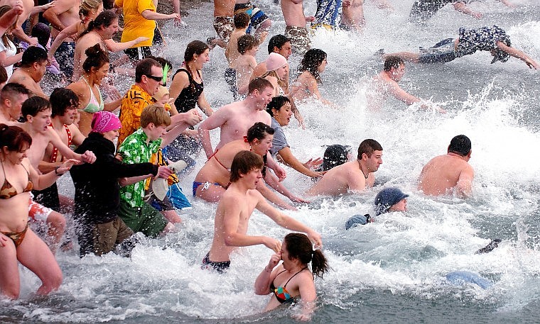 A large mass of plungers enter frigid Flathead Lake as part of a Polar Plunge next to the Raven Brew Pub and Grill in Woods Bay on New Year's Day.
