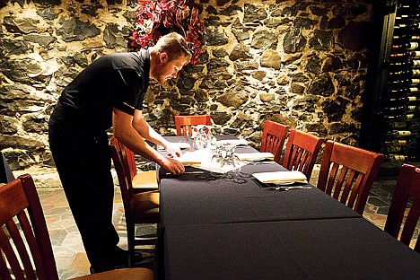 &lt;p&gt;Devon Riske, server at the Wine Cellar in Coeur d'Alene, sets a table for a large party Wednesday during his shift. Area business owners are unsure of what the 2012 economy will bring to the table.&lt;/p&gt;