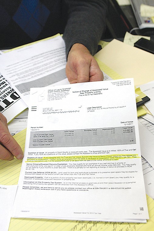 Gary Mann, of Gary Mann Real Estate, holds a copy of a Notice of
Change of Assessed Value from the Grant County Assessor's Office
for one of his properties.
