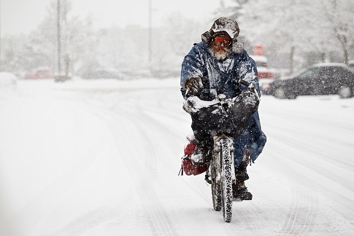 &lt;p&gt;SHAWN GUST/Press Bret Tracy rides his bicycle in snowy conditions Wednesday in Coeur d'Alene. Snow fell throughout the day causing treacherous driving conditions on area roads.&lt;/p&gt;