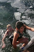 Kimberly Earhart and Jade LaDeux climb out of the freezing Clark Fork after making the plunge Saturday afternoon.