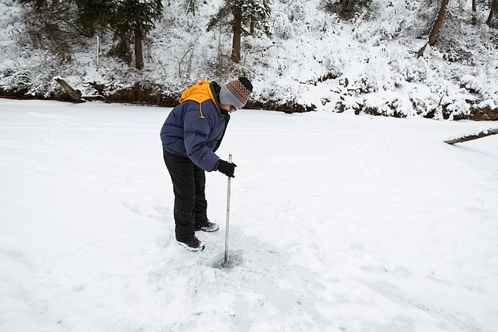 &lt;p&gt;James Morales, of Coeur d'Alene, pokes through the ice using an old broom stick while ice fishing on Fernan Lake.&lt;/p&gt;