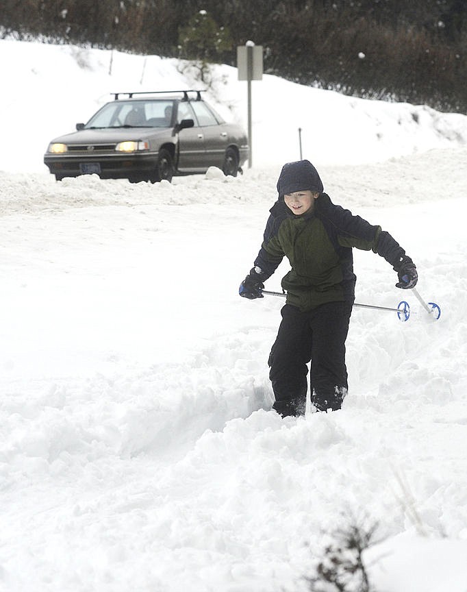 <p>Mose Moulton skis down a hill along U.S. 93 South near Lakeside on Tuesday. There was no school for students across Flathead County following two days of snow.</p>