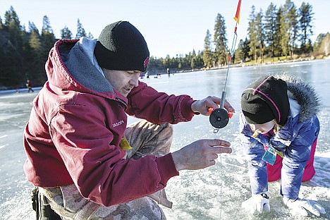 &lt;p&gt;During a family ice fishing excursion on Fernan Lake, Jason Nichols drops his line into a hole as first-time ice fisher Madison Nichols, 10, watches his technique Saturday afternoon.&lt;/p&gt;