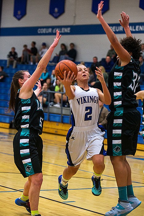 <p>Coeur dAlenes Baylie Miller goes for a layup against Lake Citys Natalie Wheelock, left, and Keara Simpson in the Coeur dAlene Vikings game against the Lake City Lady Wolves on Tuesday night.</p>