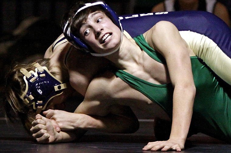 Jackson Barber (front) of Glacier stays alive in a 119-pound match despite having his arm locked.