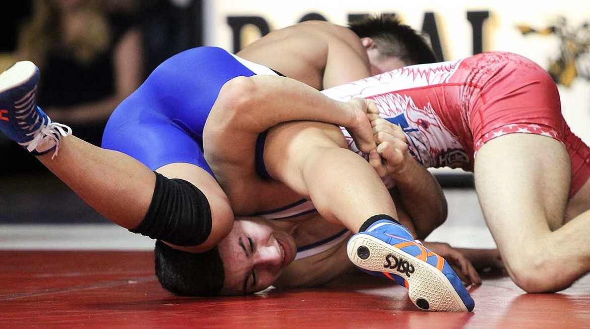 Warden's Josiah Guerra (red) tries to free himself from the grip of Taishi Narikumi. Fluaitt and Guerra wrestled as members of the Columbia Basin All-Stars against an elite Japanese team filled with Olympic hopefuls.