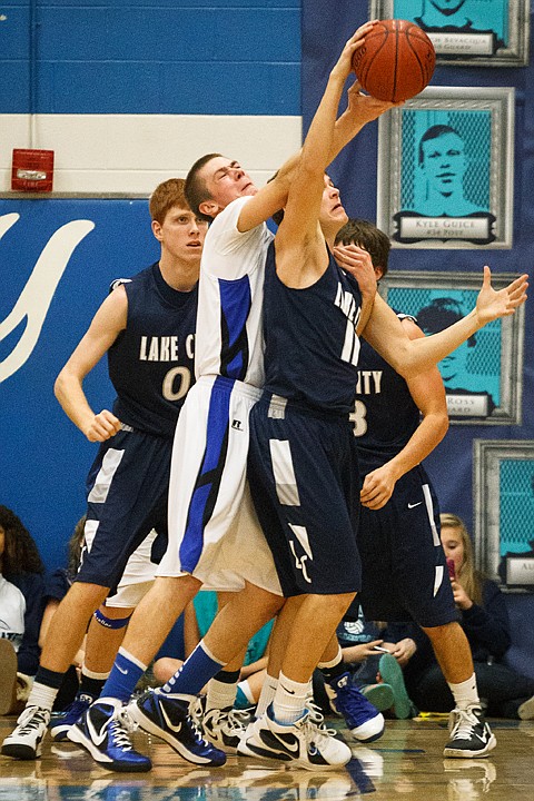 <p>SHAWN GUST/Press Coeur d'Alene's Devon Loy gets tangled with Lake City's Eric Redal while going for a second half rebound.</p>