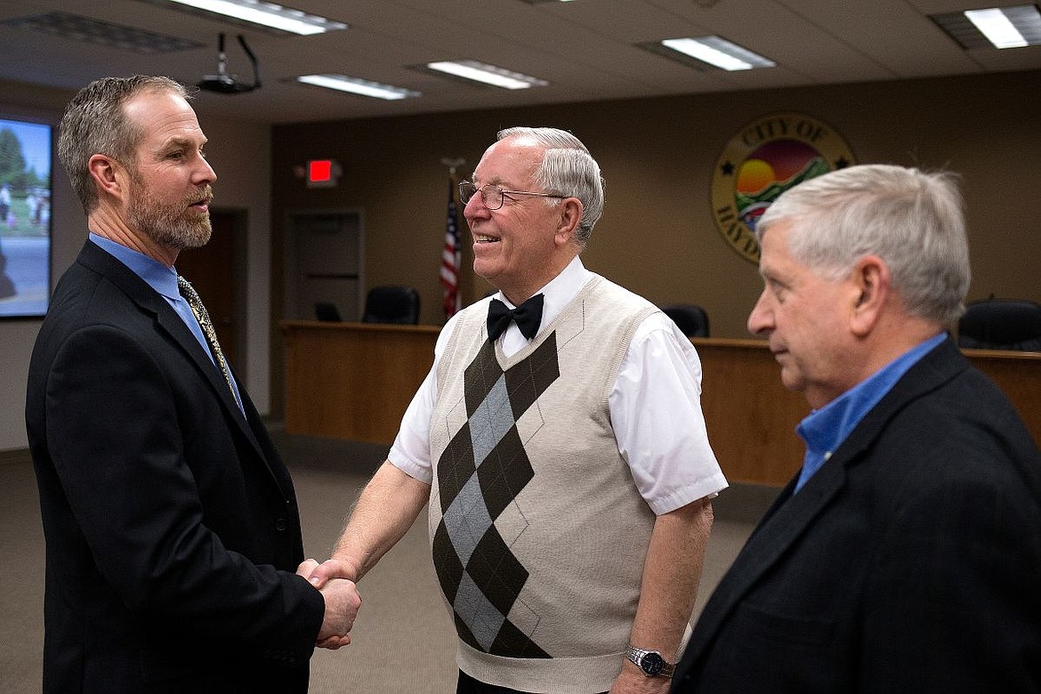 &lt;p&gt;Hayden Mayor Ron McIntire, center, shakes hands with Hayden City Attorney John Cafferty as Jerry Mason, former Hayden city attorney, watches on Wednesday at Hayden City Hall. McIntire, who has been the Mayor of Hayden for 16 years, will be stepping down from his position this month.&lt;/p&gt;