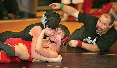 Photos by Ed Moreth&lt;br&gt;Shawn Belobradic of Missoula Hellgate tries to push off Savage Horseman Rio Crismore as referee Tom Linse signals two points to Crismore for a take-down during the Western Montana Duals at Ronan. Crismore, competing in the 98-pound weight class, pinned her opponent in 2:59. Crismore had two wins &#151; both pins &#151; and one loss at Ronan.