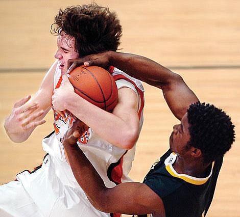 Flathead&#146;s Brock Osweiler battles for a rebound with C.M. Russell&#146;s Kelvin Steele during Flathead&#146;s 63-55 victory Saturday in Kalispell. Osweiler led all scorers with 25 points. He also pulled down a game-high 14 rebounds. Chris Jordan/Daily Inter Lake