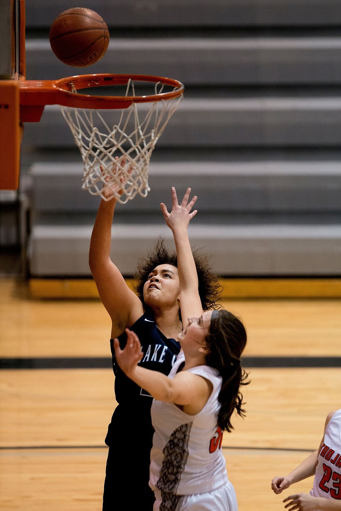 <p>JAKE PARRISH/Press Lake City's Keara Simpson takes a lay-up as Post Falls' Sydney Parks narrowly misses defending it during the second half of a face-off on Thursday at Post Falls High School.</p>