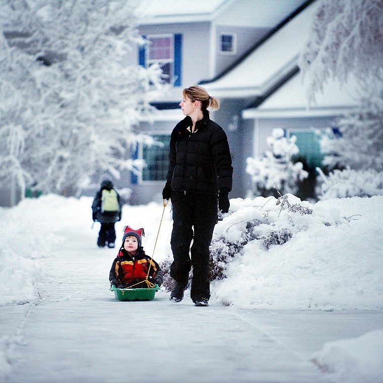 Stephanie Gulick of Kalispell pulls her 3-year-old son Carson back to their house on Tuesday morning after taking her daughters to school.