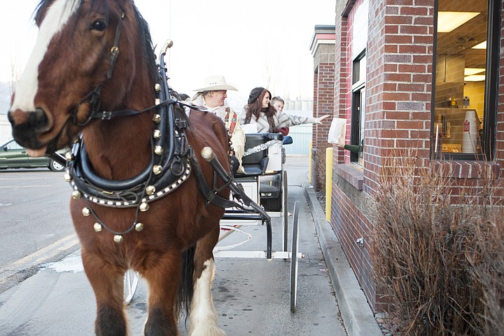 &lt;p&gt;Trinity Williams reaches from horse-drawn carriage for a bag of
food at the Wendy's drive through in Evergreen Monday evening.
Sunny, the four-year-old Clydesdale, pulled the family from their
house off of Helena Flats.&lt;/p&gt;