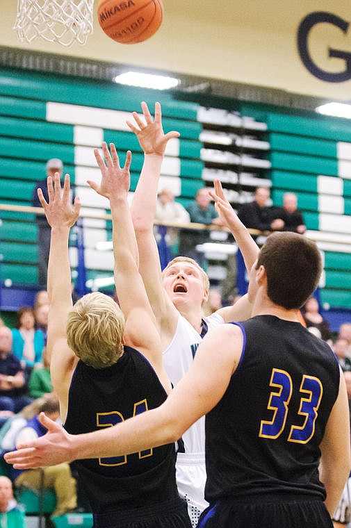 <p>Glacier senior Bryan Michaels shoots over two Missoula Big Sky defenders Friday night during Western AA basketball play at Glacier High School. (Patrick Cote/Daily Inter Lake)</p>