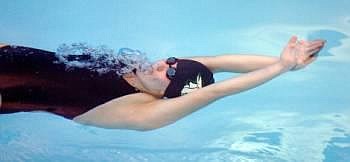 Glacier High's Tessa Heck glides underwater after pushing off the wall in the 100-yard backstroke event Saturday at The Summit pool in Kalispell. Glacier and Flathead High School competed against three Missoula high schools, with Glacier boys taking first place and Glacier girls third. Flathead's boys took fourth place, with Flathead girls placing fifth. Karen Nichols/Daily Inter Lake