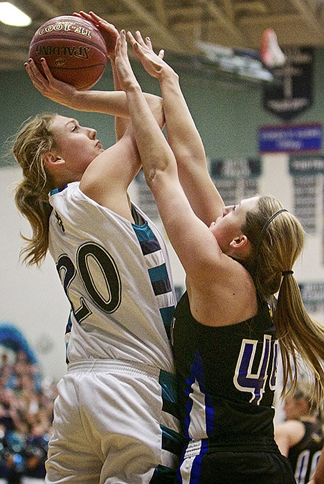 <p>Lake City High's Madi Farrell attempts to put a shot up over the arms of Sydney Williams from Coeur d'Alene.</p>