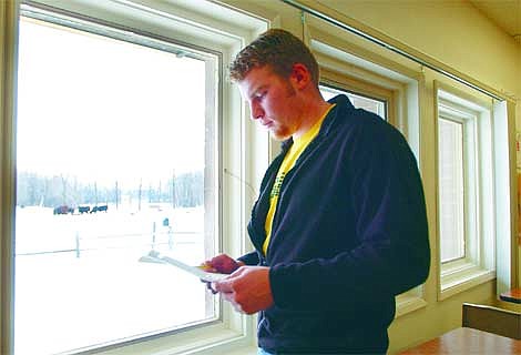 Jeremiah Allen, a Flathead High School senior and vice president of the Flathead FFA chapter, glances over a list of contacts for a research project on a proposed wastewater treatment plant which may be located in the field visible through the window. The high school's vo-ag program currently uses the field on the south side of Kalispell as a pasture and animal science study area. Jennifer DeMonte/Daily Inter Lake