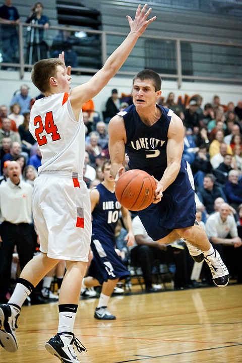 <p>Lake City High's Chris Wheelock leaps forward under the arm of Michael Hillman from Post Falls during the first half.</p>