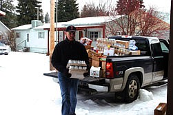 Dennis Kimzey carries a box of food from the truck load last Thursday. He was one of the many volunteers that helped the food bank relocate to its new location.