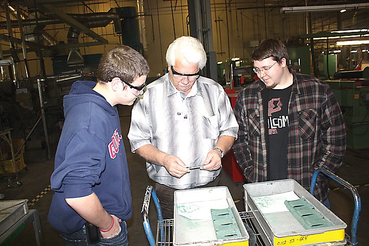 Chuck Buck (center) describes the reason for a particular step in the making of a knife, while Ted Mead (left) and Josh Buck watch.