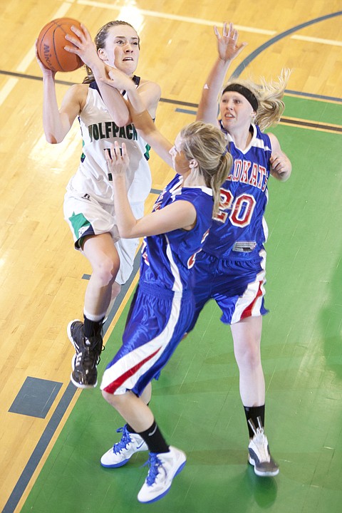 <p>Glacier's Rachel Chery (left) goes up for a shot over two
Columbia Falls Wildkat defenders during the Wolfpack's win Friday
night.</p>