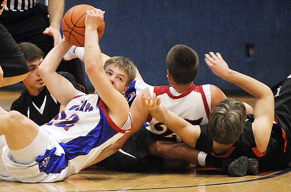 Columbia Falls senior Chris King, 22, hangs onto the ball during a pile up of players as members of both teams go after a jump ball during the game against Ronan on Friday in Columbia Falls.