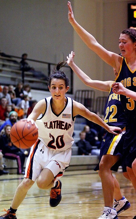 Flatheads Taylor Keltner drives around Missoula Big Skys Danielle Sheridan (31) and Tali Hart in the second half of Friday evenings Western AA basketball game in Kalispell.