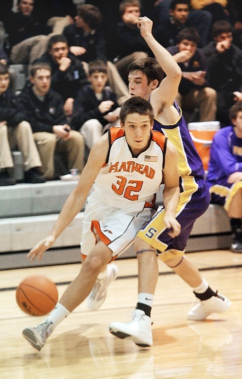 Flathead sophomore George Sherwood (32) drives around a Missoula Sentinel defender during Tuesdays game at Flathead.