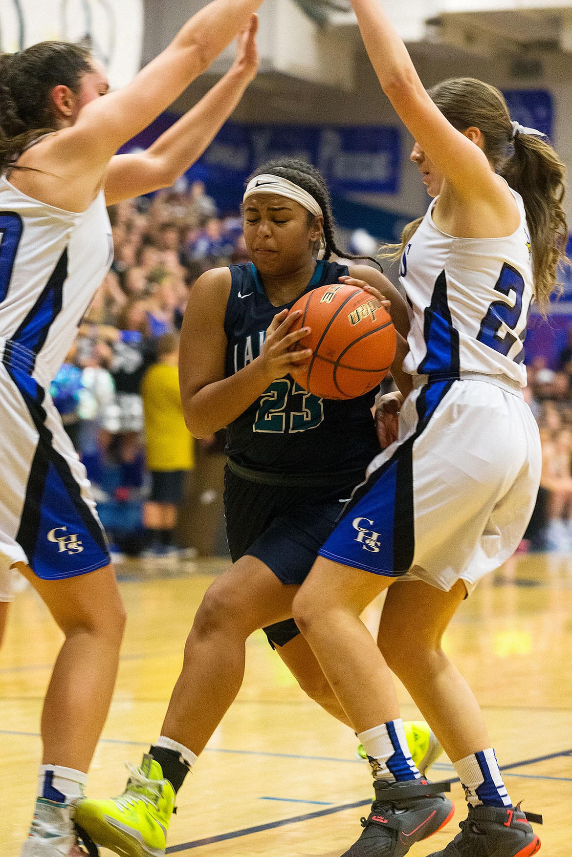 <p>Lake Citys Whitney Meier splits two Coeur dAlene defenders while driving to the basket in the fourth quarter.</p>