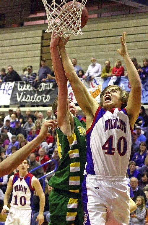 Columbia Falls' Jacob Calderwood stretches his arms up as he goes for a rebound against Whitefish's Connor Silliker in the final minutes of Saturday's game in Columbia Falls.
