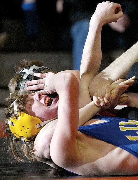 Libby&#146;s Kelbee Sweedman grimaces while trying to fight out of the grip of Flathead&#146;s Ricky Janes during Tuesday night&#146;s 130-pound match at Flathead High School. Janes pinned Sweedman at 1:10 in the first round. Craig Moore/Daily Inter Lake