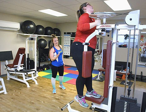 &lt;p&gt;Fitness Connexion trainer Nicolette Isaacs instructs Katie Barling on how to use a weight machine for a step up exercise at the gym in Bloomington, Ill., Dec. 1, 2014. The routine boosts heart rate and firms leg muscles. Barling has made drastic lifestyle changes to her life since joining the gym in the summer of 2012.&lt;/p&gt;