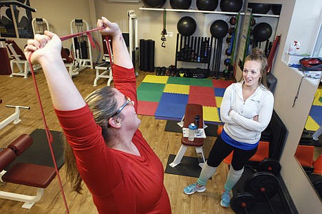 &lt;p&gt;Katie Barling talks with trainer Nicolette Isaacs while working out on a resistance band at the Fitness Connexion in Bloomington, Ill., Dec. 1, 2014.&lt;/p&gt;