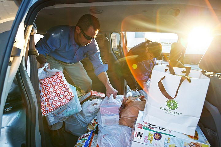 &lt;p&gt;SHAWN GUST/Press Tim Elder, general sales manager for Sunset Motors, left, is helped by volunteer Pedro Dos Santos Thursday in unloading a van full of food donations at Community Action Partnership in Coeur d'Alene. The car dealership staff collected nearly 1,000 pounds of items for the food bank in one week.&lt;/p&gt;