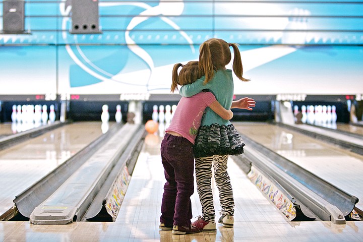 &lt;p&gt;JEROME A. POLLOS/Press Bailey Burke, 3, holds onto her sister Madison, 5, as they patiently wait for their bowling ball to slowly make its way down the lane Thursday as it skids off the bumper at Sunset Bowling in Coeur d'Alene. The girls made their first bowling trip with their mom as part of a food drive for the Idaho Connections Academy.&lt;/p&gt;