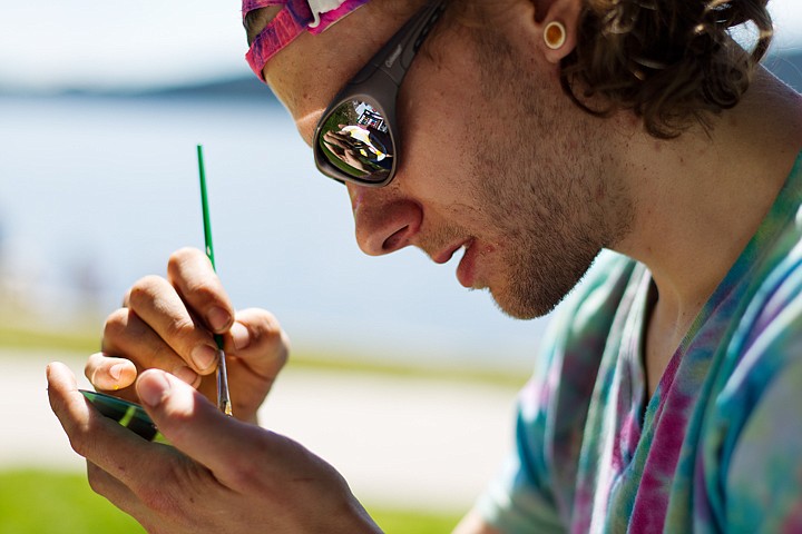 &lt;p&gt;Joshua Myers paints the label side of a music CD Wednesday while enjoying the warm weather at the city park in Coeur d'Alene. (SHAWN GUST/Press)&lt;/p&gt;