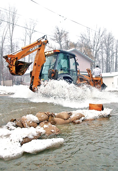 Workers travel Nevada Avenue by way of excavator. City and county crews, as well as a few contractors, helped break up the stream&#146;s ice with excavators in order to prevent further ice jams.
