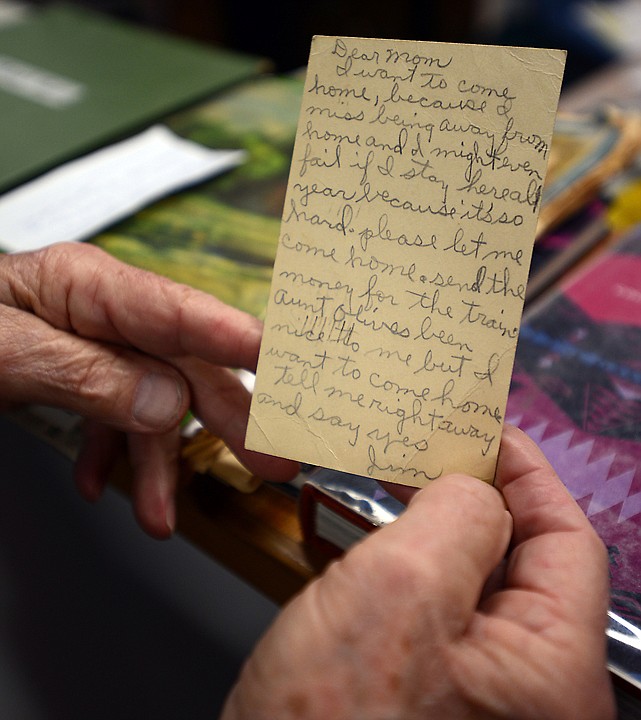 <p>Duford displays a postcard he wrote at age 12 when he first arrived in Montana.</p>